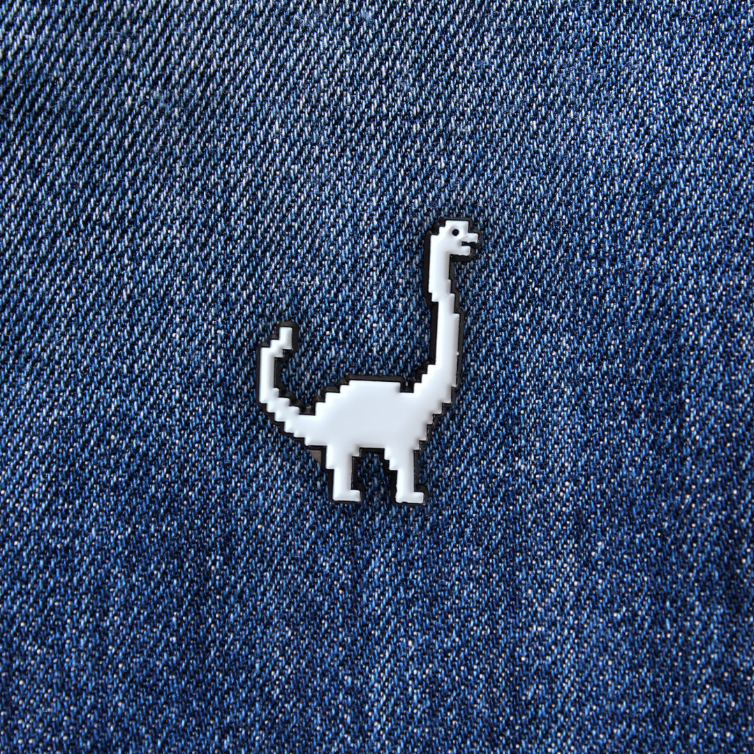 Pins Brachiosaure pixelisé sur un jean