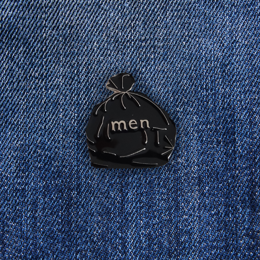 Pins Men Are Trash sur un jean