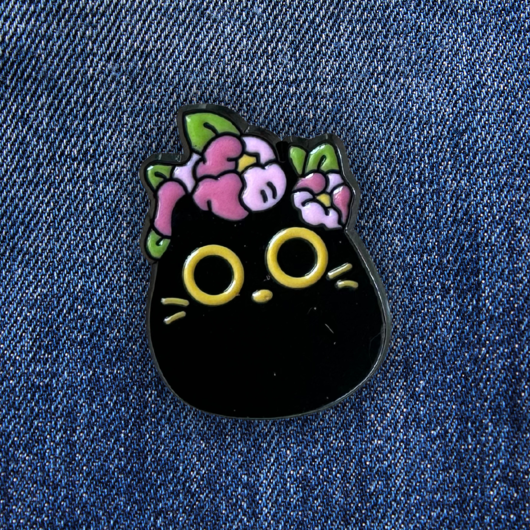 Pins Chat Noir Parsemé de Fleurs sur un jean